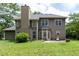 This is the home's backyard and exterior, which features lots of green grass and mature trees and a brick chimney at 3554 Cherry Blossom Ct, Loganville, GA 30052