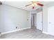 This bedroom features lovely gray walls, new gray floors, a ceiling fan, a window, and a white door at 3554 Cherry Blossom Ct, Loganville, GA 30052