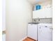 Functional laundry room with white washer, dryer, and storage cabinets at 3554 Cherry Blossom Ct, Loganville, GA 30052
