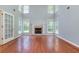 Open living area with a fireplace, large windows, hardwood floors and French doors to adjoining room at 3554 Cherry Blossom Ct, Loganville, GA 30052