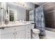 Bathroom featuring large mirror, grey tile accent wall, shower-tub, and stylish vanity at 195 Ansley Ct, Roswell, GA 30076