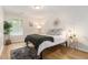 Cozy bedroom featuring a large window, a side table with a lamp, and a decorative mirror at 195 Ansley Ct, Roswell, GA 30076
