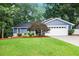 Charming blue home featuring a well-manicured lawn, landscaping, and a two-car garage at 195 Ansley Ct, Roswell, GA 30076