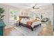 Bright bedroom featuring wood bed frame, ceiling fan, mirrored closet, and natural light at 195 Ansley Ct, Roswell, GA 30076