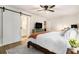 Spacious bedroom featuring a barn door to the bathroom, ceiling fan, and light wood floors at 195 Ansley Ct, Roswell, GA 30076
