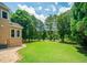 A lush green lawn bordered by trees and shrubbery is visible from the side of the home at 2521 Wood Creek Ct, Dacula, GA 30019