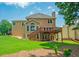 Spacious backyard featuring a wooden deck, lush green lawn, and mature trees for privacy at 2521 Wood Creek Ct, Dacula, GA 30019
