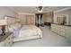 Well-lit bedroom with neutral walls, a large bed, side tables, and a dresser with a mirror at 2521 Wood Creek Ct, Dacula, GA 30019