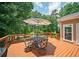 Outdoor deck featuring a dining set and umbrella, perfect for entertaining or relaxing in the fresh air at 2521 Wood Creek Ct, Dacula, GA 30019
