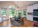 Sunlit dining area with a glass-top table and scenic outdoor views through multiple windows at 2521 Wood Creek Ct, Dacula, GA 30019