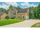 Charming two-story home with manicured lawn and long driveway to the side-entry garage, surrounded by mature trees at 2521 Wood Creek Ct, Dacula, GA 30019