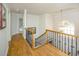 Elegant hallway with hardwood floors, decorative lighting, and iron-wrought banister at 2521 Wood Creek Ct, Dacula, GA 30019