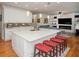 Open concept kitchen featuring white cabinetry, a large island with seating, stainless appliances, and hardwood floors at 2521 Wood Creek Ct, Dacula, GA 30019