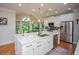 Bright kitchen with white cabinets, a large island, stainless appliances, hardwood floors, and a view of the breakfast nook at 2521 Wood Creek Ct, Dacula, GA 30019