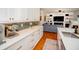 Modern kitchen with white cabinets, stainless steel appliances, hardwood floors, and an open layout to the living area at 2521 Wood Creek Ct, Dacula, GA 30019