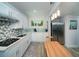 Modern kitchen features stainless appliances, quartz counters, custom tile, and durable floors at 2521 Wood Creek Ct, Dacula, GA 30019