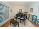 Bright living room featuring a grand piano, decorative rug, and art-filled walls, creating a cultural atmosphere at 2521 Wood Creek Ct, Dacula, GA 30019