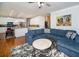 Open concept living room with hardwood floors, a large blue sectional, and direct access to the updated kitchen at 2521 Wood Creek Ct, Dacula, GA 30019