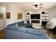 Comfortable living room with a plush sectional sofa, a modern fireplace, a ceiling fan, and an entertainment center at 2521 Wood Creek Ct, Dacula, GA 30019