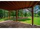 Covered outdoor patio with stone flooring and view of the lush backyard at 2521 Wood Creek Ct, Dacula, GA 30019
