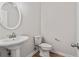 A well-lit half bath with a pedestal sink and toilet at 2934 Mill Grove Ter, Dacula, GA 30019