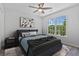 Bright bedroom with a ceiling fan, large window, and comfortable bed with stylish decor at 2934 Mill Grove Ter, Dacula, GA 30019