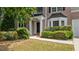 Close-up of the front entrance with brick facade, manicured shrubs, and a black front door at 2934 Mill Grove Ter, Dacula, GA 30019