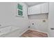 A bright laundry room featuring white cabinets and hardwood floors at 2934 Mill Grove Ter, Dacula, GA 30019