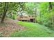 View of a yellow house with a large wooden deck and lush surrounding landscape at 3812 Clare Ct, Duluth, GA 30096