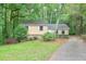 Inviting single-Gathering home featuring a quaint front yard and a long driveway surrounded by mature trees at 3812 Clare Ct, Duluth, GA 30096