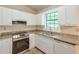 Updated kitchen featuring white cabinets, granite countertops, and modern stainless steel appliances at 3812 Clare Ct, Duluth, GA 30096
