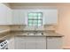 Bright kitchen featuring white cabinets, granite countertops, stainless steel appliances, and a garden view at 3812 Clare Ct, Duluth, GA 30096