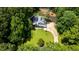 Expansive aerial view reveals a home nestled among lush greenery with a winding driveway and outdoor living spaces at 4070 Whitewater Creek Rd, Atlanta, GA 30327