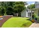 Expansive backyard features a putting green, lush greenery, and a modern house extension with large windows at 4070 Whitewater Creek Rd, Atlanta, GA 30327