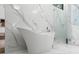 Bright bathroom featuring a modern standalone tub and marble walls and floors at 4070 Whitewater Creek Rd, Atlanta, GA 30327