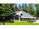 Striking exterior of a home with stone accents, gray siding, and a manicured lawn surrounded by mature trees at 4070 Whitewater Creek Rd, Atlanta, GA 30327