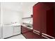 Modern laundry room features a sleek washer and dryer next to red cabinetry, maximizing space and style at 4070 Whitewater Creek Rd, Atlanta, GA 30327