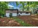 A large, shady backyard with a two-tone house featuring white brick and brown siding at 4260 Bonaparte Dr, Tucker, GA 30084