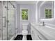 Bright bathroom featuring marble shower, black tile floor, and a modern vanity with a lighted mirror at 4260 Bonaparte Dr, Tucker, GA 30084