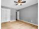 Neutral bedroom features sleek floors, a ceiling fan, and white closet doors at 4260 Bonaparte Dr, Tucker, GA 30084