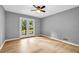 Empty room with sleek floors, gray walls, ceiling fan and glass doors to outside at 4260 Bonaparte Dr, Tucker, GA 30084