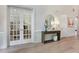 Elegant foyer with hardwood floors, paneled walls, and decorative console table with mirror at 904 Urban Ash Ct, Johns Creek, GA 30022