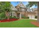 Charming two-story brick home with a well-manicured lawn, mature trees, and a two-car garage at 904 Urban Ash Ct, Johns Creek, GA 30022