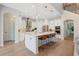 Bright, white kitchen with stainless appliances, a large island with seating, and hardwood floors at 904 Urban Ash Ct, Johns Creek, GA 30022