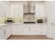 Beautiful kitchen featuring white cabinets, stainless steel appliances, and a modern range hood at 904 Urban Ash Ct, Johns Creek, GA 30022