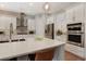 Modern kitchen with stainless steel appliances, white cabinets, and a large center island at 904 Urban Ash Ct, Johns Creek, GA 30022