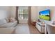 Comfortable living room with a modern sofa, large window, and wall-mounted TV for relaxation at 904 Urban Ash Ct, Johns Creek, GA 30022