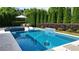 Backyard featuring a luxurious in-ground pool with a spa, waterfall feature, and surrounding patio at 904 Urban Ash Ct, Johns Creek, GA 30022