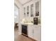 Convenient wet bar with custom cabinets, wine fridge, quartz countertops, and beverage storage at 904 Urban Ash Ct, Johns Creek, GA 30022