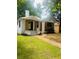 This home features updated landscaping, fresh green lawn, and beautiful white brick exterior with charming wood design accents at 1460 Hartford Sw Ave, Atlanta, GA 30310